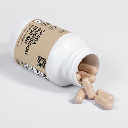 Open bottle of supplements with pills spilling out on a white background